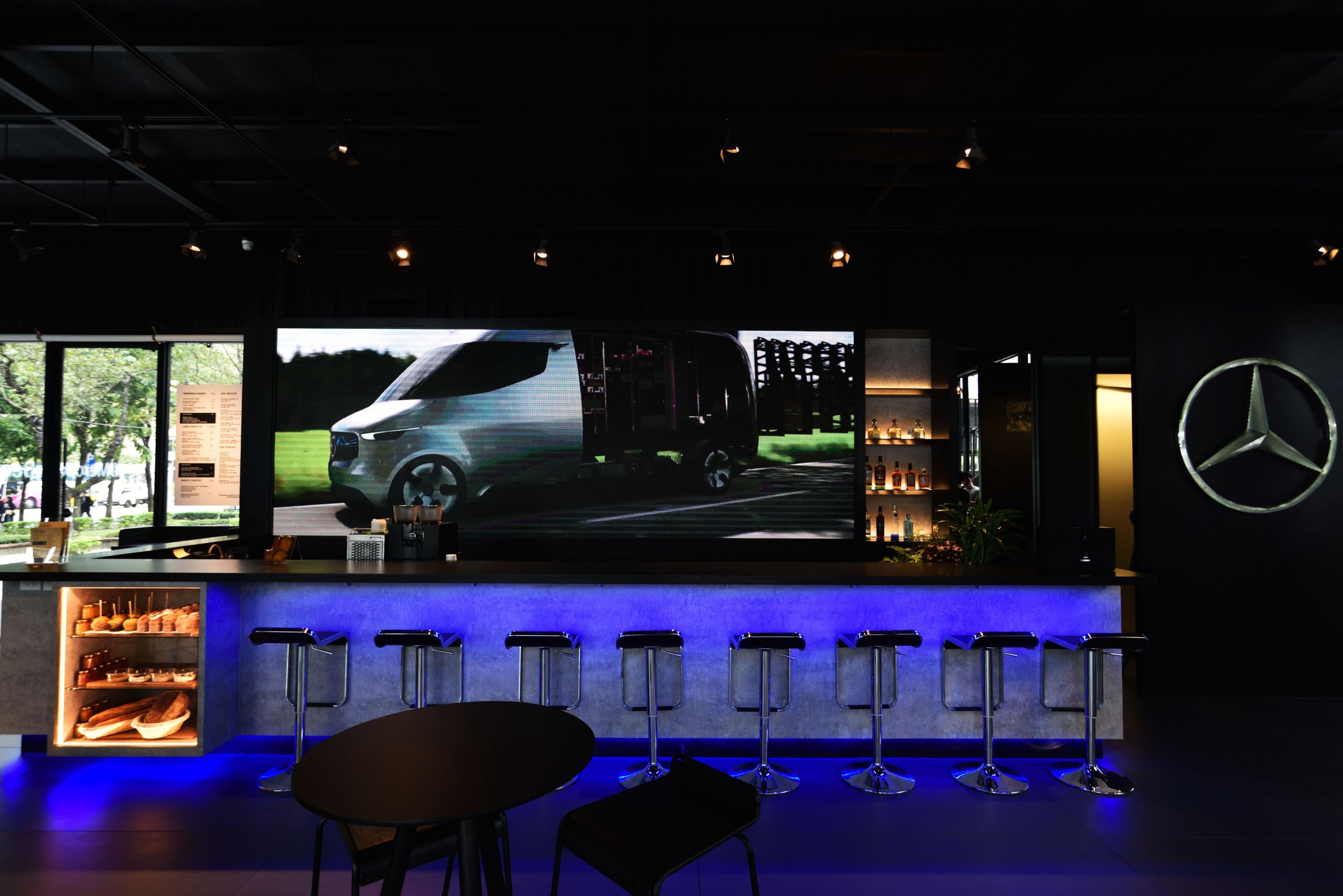 藍冷光色調的吧檯區搭配後方巨大的LED螢幕塑造未來科技感.JPG